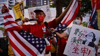 Seorang demonstran merobek bendera Amerika Serikat.