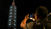 Seseorang mengambil foto tulisan TW Love US di Menara 101, Taipei. 