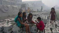 Sejumlah anak berkumpul bersama sambil makan dan juga ngobrol. Terlihat asap di belakang mereka yang sudah mulai tebal.