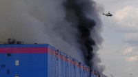 Asap tampak membubung dari gudang Ozon yang terbakar.