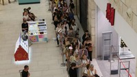 Warga antre di luar toko, memanjang hingga melewati toko sebelah. H&M adalah salah satu dari banyak merek yang menarik diri dari Rusia dalam beberapa bulan terakhir. 