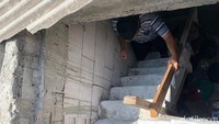 Asep meniti tangga dari dalam rumah keponakannya yang berada tepat di samping rumahnya. Kemudian, mereka harus berjalan dari atas balkon dan melompati sebuah pagar yang membatasi rumah Mursideh dengan balkon tersebut. (Mulia Budi/detikcom)