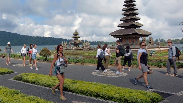 Wisatawan menikmati pemandangan objek wisata Ulun Danu Beratan saat berkunjung di Tabanan, Bali, Kamis (4/8/2022). Berdasarkan data dari Badan Pusat Statistik Provinsi Bali mencatat kunjungan wisatawan mancanegara ke Bali pada bulan Juni 2022 meningkat 57,10 persen yakni sebanyak 181.625 orang dibandingkan bulan Mei yang tercatat 115.611 orang, dan kedatangan wisman ke Bali didominasi wisatawan asal Australia. ANTARA FOTO/Nyoman Hendra Wibowo/foc.