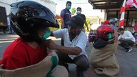 Petugas membantu memasangkan helm kepada peserta lomba balap karung di Liponsos Keputih, Surabaya, Jawa Timur, Rabu (3/8/2022).