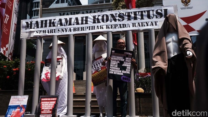Sekelompok warga dari gerakan Bersihkan Indonesia menggelar aksi menolak UU Minerba di depan gedung MK. Instalasi seni dipajang sebagai bentuk protes.