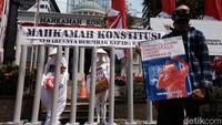 Gerakan Bersihkan Indonesia memasang instalasi seni bertemakan Terpenjara dalam UU Minerba di depan gedung MK, Jl Medan Merdeka Barat, Kamis (4/8/2022).