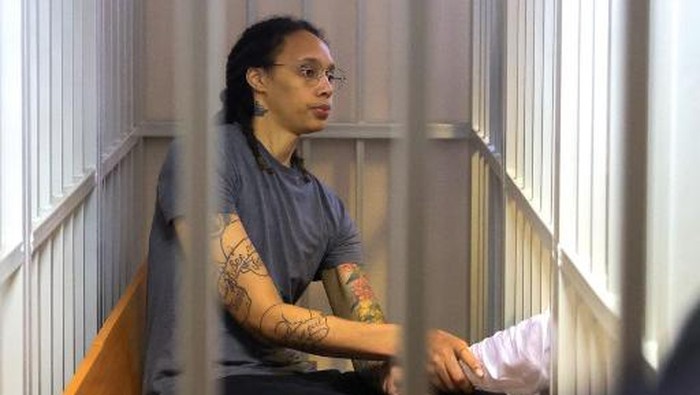 US Womens National Basketball Association (NBA) basketball player Brittney Griner, who was detained at Moscows Sheremetyevo airport and later charged with illegal possession of cannabis, sits inside a defendants cage after the courts verdict during a hearing in Khimki outside Moscow, on August 4, 2022. - A Russian court found Griner guilty of smuggling and storing narcotics after prosecutors requested a sentence of nine and a half years in jail for the athlete. (Photo by EVGENIA NOVOZHENINA / POOL / AFP)