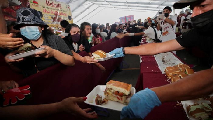 Sandwich Raksasa Sepanjang 74 Meter di Meksiko Pecahkan Rekor Dunia Workers and exhibitors prepare a giant Torta of 74.2 meters long during the Torta fair, attempting at the world's largest sandwich (commonly called Torta in Mexico), in Mexico City, Mexico. August 3, 2022. REUTERS/ Henry Romero