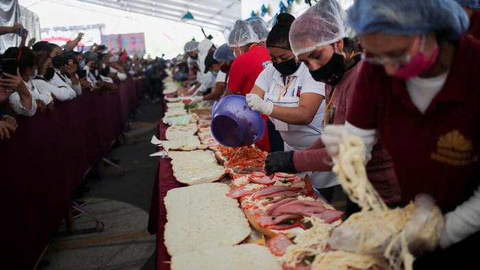 Sandwich Raksasa Sepanjang 74 Meter di Meksiko Pecahkan Rekor Dunia Workers and exhibitors prepare a giant Torta of 74.2 meters long during the Torta fair, attempting at the world's largest sandwich (commonly called Torta in Mexico), in Mexico City, Mexico. August 3, 2022. REUTERS/ Henry Romero