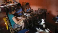 Sebuah keluarga membungkus cerutu di rumah. Mereka terlihat kompak saling membantu satu sama lain.