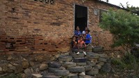 Sebuah keluarga duduk di tangga luar rumah mereka yang terbuat dari ban. Cerutu Venezuela cukup dikenal di kalangan pecinta tembakau. 