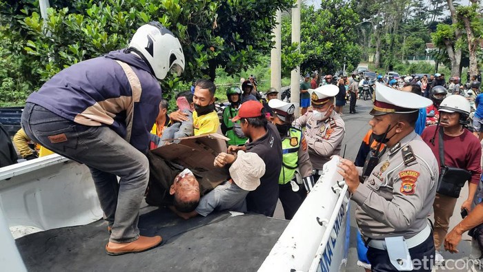 Warga dan petugas mengevakuasi pengendara motor yang diseret truk di Bandar Lampung.