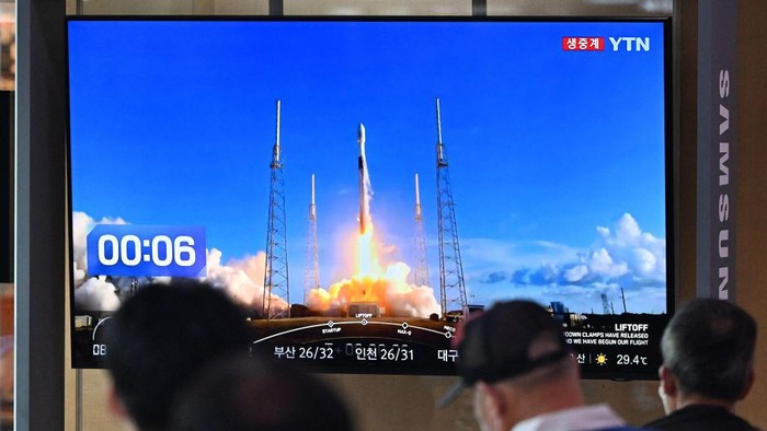 People watch a television screen showing a live footage of a SpaceX Falcon 9 rocket launching with South Koreas first lunar orbiter Danuri onboard from Cape Canaveral in Florida, at a railway station in Seoul on August 5, 2022. (Photo by Jung Yeon-je / AFP) (Photo by JUNG YEON-JE/AFP via Getty Images)