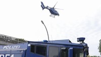Mobil penyemprot air tiba di dekat lokasi kebakaran saat helikopter polisi terbang di atas. (Sean Gallup/Getty Images)
