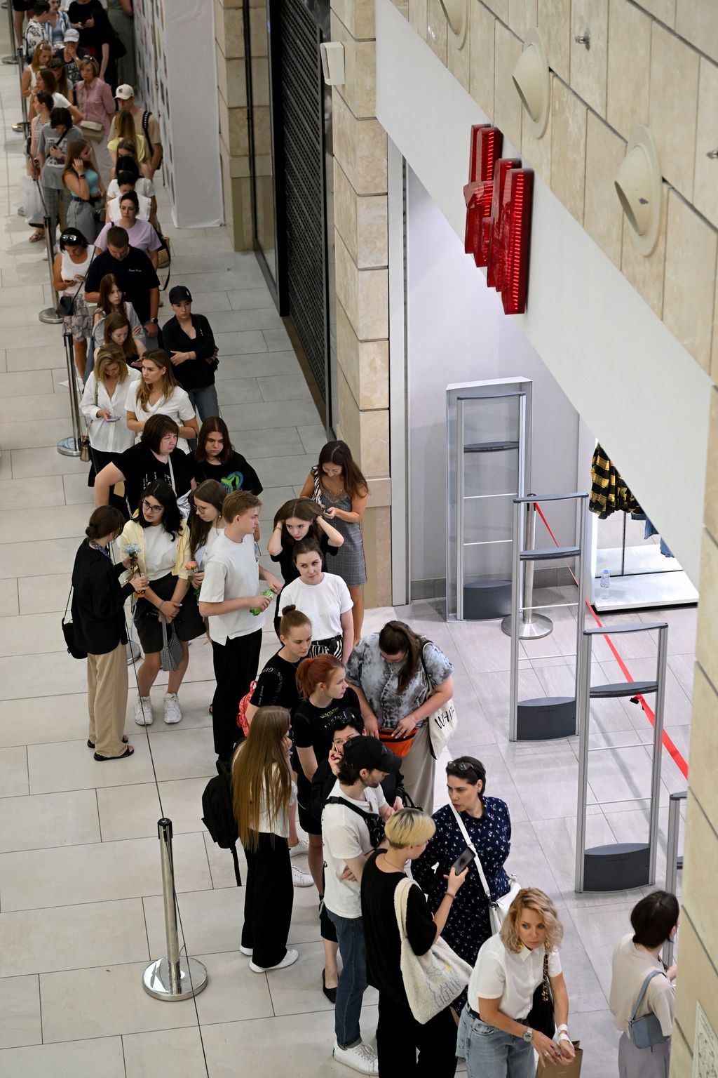 People queue outside an H&M clothing store, which opened the final sales before shuting down its business operations in Russia, at the Metropolis shopping centre in Moscow on August 3, 2022. (Photo by NATALIA KOLESNIKOVA / AFP) (Photo by NATALIA KOLESNIKOVA/AFP via Getty Images)