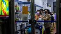 Warga menonton siaran televisi di gerai pangkas rambut, di Ibu Kota Taipei, Kamis (4/8/2022). (Annabelle Chih/Getty Images)