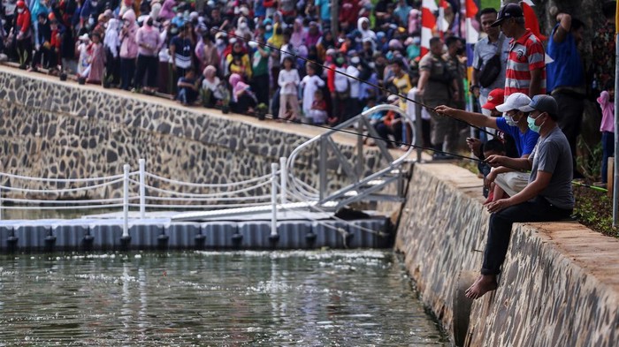 Gaya Ridwan Kamil dan Bonge Catwalk di Situ Rawa Kalong Gubernur Jawa Barat Ridwan Kamil (kanan) berjalan bersama Bonge (kiri) di atas floating brigde saat peresmian Situ Rawa Kalong di Curug, Depok, Jawa Barat, Jumat (5/8/2022). Selesainya revitalisasi Situ Rawa Kalong yang dilengkapi dengan beberapa fasilitas seperti jogging track, tembok mural dan floating brigde bertujuan menjadikan situ sebagai tempat destinasi wisata.