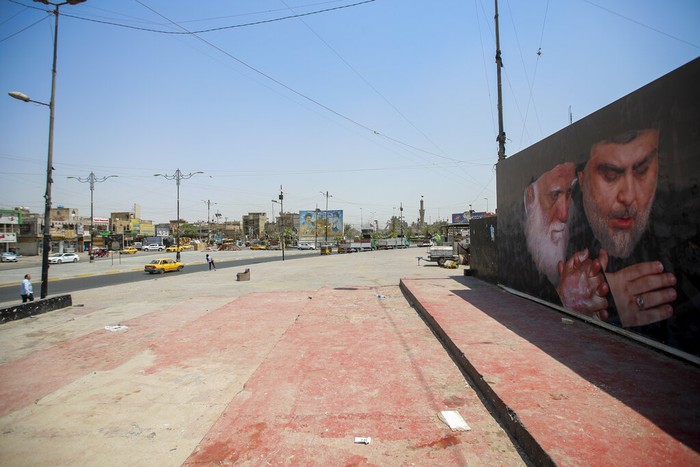 Iraq People navigate a street with a poster of Shiite religious leaders Mohammed Sadiq al-Sadr, right, and his relative, Mohammed Baqir al-Sadr, left, displayed in Baghdad's Shiite enclave of Sadr City, in Baghdad, Iraq, Thursday, Aug. 4, 2022. Residents of the impoverished suburb say they they support an influential Shiite cleric who called on thousands of his followers to storm Iraq's parliament. (AP Photo/Anmar Khalil)