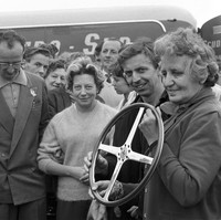 Penasaran dengan sosok asli Laura Ferrari? Di foto tertanggal 16 Juli 1960 ini, Laura berada di pojok kiri. Ia hendak memberikan tropi kepada pebalap Tony Brooks saat ajang Grand Prix of Great Britain. (Foto: GC Images/MEGA)