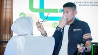 Tanpa ragu, Ibu Suriani langsung menyemprotkan produk buatannya ke wajah Sandiaga. Produk herbal cair itu disebut Suriani bermanfaat untuk menyegarkan mata. (dok. Kemenparekraf)