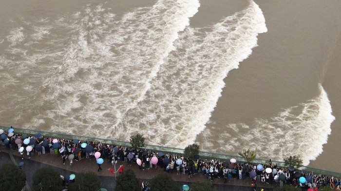1278616495 HANGZHOU, CHINA - OCTOBER 04: Aerial view of tourists watching Qiantang River tidal bore on the 18th day of the eighth month in the Chinese lunar calendar on October 4, 2020 in Hangzhou, Zhejiang Province of China. (Photo by Li Xiaowei/VCG via Getty Images)