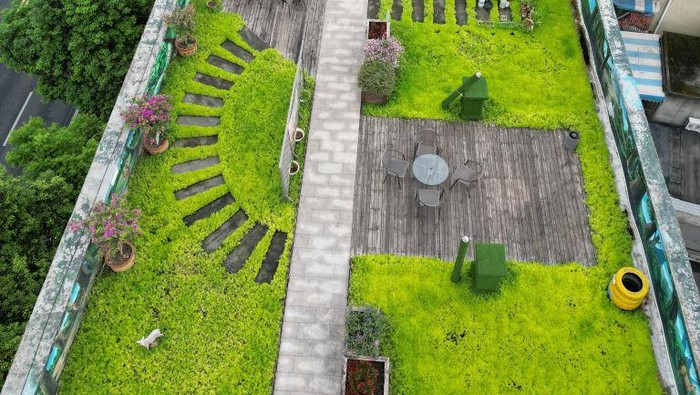 1413038427 CHENGDU, CHINA - AUGUST 05: Aerial view of a rooftop garden being built atop an old residential building on August 5, 2022 in Chengdu, Sichuan Province of China. Residents of 60 households demolished the illegal facilities built on the rooftop and transformed it into a 1,100-square meter shared garden. (Photo by Zhang Lang/China News Service via Getty Images)