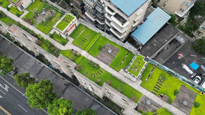 CHENGDU, CHINA - AUGUST 05: Aerial view of a rooftop garden being built atop an old residential building on August 5, 2022 in Chengdu, Sichuan Province of China. Residents of 60 households demolished the illegal facilities built on the rooftop and transformed it into a 1,100-square meter shared garden. (Photo by Zhang Lang/China News Service via Getty Images)