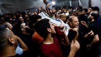 Jenazah seorang gadis Palestina dibawa oleh sejumlah warga di rumah sakit setelah terbunuh akibat serangan rudal Israel. (Ibraheem Abu Mustafa/Reuters)