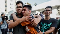 Warga Palestina menangis dan saling menguatkan satu sama lain setelah kejadian ledakan tersebut. (Ibraheem Abu Mustafa/Reuters)