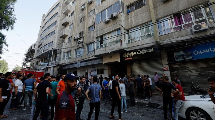 ISRAEL-PALESTINIANS/GAZA Emergency responders evacuate a woman from a building after an explosion, following Israeli strikes in Gaza, in Gaza City August 5, 2022. REUTERS/Mohammed Salem