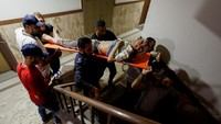 Sejumlah orang mengevakuasi seorang pria tua yang terluka akibat ledakan. Pria tersebut segera dibawa ke rumah sakit. (Mohammed Salem/Reuters)
