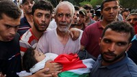 Kakek gadis Palestina Alaa Qadoum menggendong jenazahnya cucunya untuk dibawa ke pemakaman. (Ashraf Amra/Reuters)