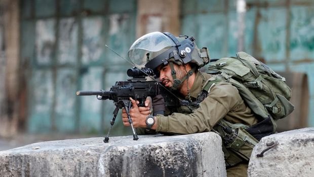An Israeli army soldier aims his weapon during clashes against Israeli strikes in Gaza, in Hebron in the Israeli-occupied West Bank August 5, 2022. REUTERS/Mussa Qawasma