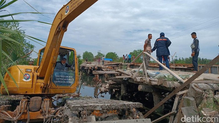 Jembatan rusak dilewati ekskavator.