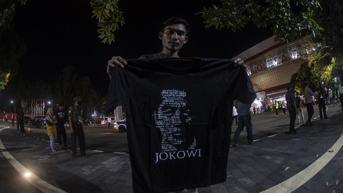 Warga menunjukan kaos bertuliskan Jokowi yang dibagikan oleh Presiden Joko Widodo usai menghadiri Upacara Penuntupan ASEAN Para Games 2022 di Stadion Manahan, Solo, Jawa Tengah, Sabtu (6/8/2022). ANTARA FOTO/Muhammad Adimaja/YU