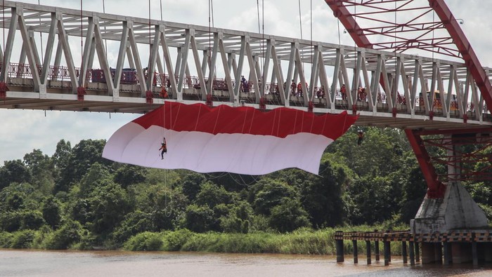 PEMBENTANGAN BENDERA MERAH PUTIH DI JEMBATAN KAHAYAN Foto udara sebuah bendera merah putih dibentangkan di Jembatan Kahayan, Palangka Raya, Kalimantan Tengah, Sabtu (6/8/2022). Aksi pembentangan bendera merah putih sepanjang 40 x 8 meter tersebut diikuti oleh TNI, Polri, Basarnas, BPBD, dan relawan ERP yang bertujuan untuk menumbuhkan rasa jiwa nasionalisme kepada generasi muda serta menyemarakkan HUT ke-77 Kemerdekaan Republik Indonesia. ANTARA FOTO/Makna Zaezar/nz
