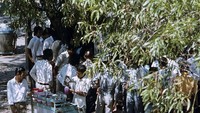 Penjual es serut dan orang-orang berkerumun di sebuah taman di Jakarta. Potret penjual es serut ini terjadi sekitar tahun 1980. Foto: Henk van Rinsum 
