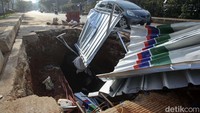 Tampak penutup sebuah proyek rusak parah dan mengakibatkan lubang menganga tampak penghalang.