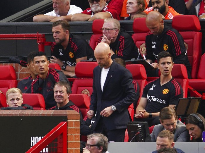 Manchester United's Cristiano Ronaldo, left, sits on the bench as his coach Erik ten Hag stands during the English Premier League soccer match between Manchester United and Brighton at Old Trafford stadium in Manchester, England, Sunday, Aug. 7, 2022. (AP Photo/Dave Thompson)
