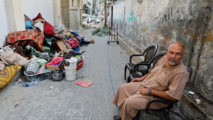 A Palestinian man sits in a street near the scene where senior commander of Islamic Jihad militant group Khaled Mansour was killed in Israeli strikes, in Rafah in the southern Gaza Strip, August 7, 2022. REUTERS/Ibraheem Abu Mustafa