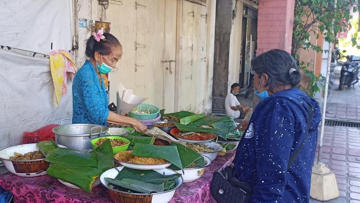 Made Sumbru sedang melayani pembeli blayag, Minggu (7/8/2022).