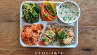Menu makan siang di sekolah Korea Selatan umumnya berupa nasi. Ada juga kimchi yang tidak boleh ketinggalan dan potongan kue ikan di atas nasi goreng. Foto: madeformums.com