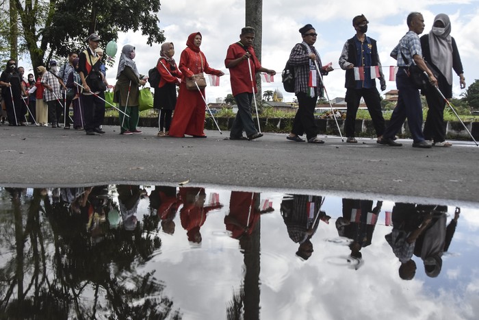 Penyandang tunanetra mengikuti long march rally tongkat dalam rangkaian menyambut HUT ke-77 Kemerdekaan di Saptamarga, Kota Tasikmalaya, Jawa Barat, Minggu (7/8/2022). Rally tongkat yang diikuti oleh 246 peserta tunanetra se-Priangan Timur dan Bandung itu berziarah ke taman makam pahlawan untuk mengenang jasa para pahlawan sekaligus melatih kemandirian tunanetra mengenai tata cara berjalan menggunakan tongkat. ANTARA FOTO/Adeng Bustomi/foc.
