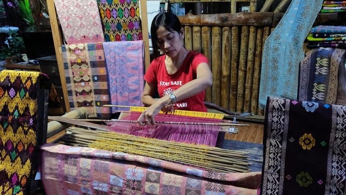 Wow! Kain Tenun Jembrana Bali Diekspor ke Amerika Serikat Perajin Gusti Ayu Putu Windi Astari menyelesaikan pembuatan kain tenun cagcag dengan teknik tradisional di Sanggar Tenun Kembar Sari, Desa Batu Agung, Jembrana, Bali, Sabtu (6/8/2022). Kerajinan kain tenun khas Jembrana yang diproduksi di tempat tersebut mempertahankan teknik tradisional sebagai upaya pelestarian budaya Bali dan produk tenun karyanya pada bulan Juli 2022 diekspor ke Amerika Serikat dengan harga jual Rp100 ribu hingga Rp4 juta per lembar sesuai jenis, motif dan kualitas. ANTARA FOTO/Nyoman Hendra Wibowo/rwa.
