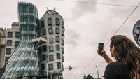 Seorang warga terlihat mengabadikan suasana gedung menggunakan gadget.