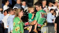 Pemenang jersey hijau TDF 2022, Wout van Aert menghampiri Sarah De Bie dan Georges van Aert usai menuntaskan etape ke-21 TDF di Paris, 24 Juli 2022. Istri dan anaknya tersebut diajak naik ke podium untuk merayakan selebrasi sebagai sprinter tercepat pada balap sepeda paling bergengsi itu. (Jean Catuffe/Getty Images)