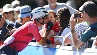Mark Cavendish mencium anaknya usai membalap di pekan olahraga negara-negara persemakmuran di Birmingham, Inggris, 7 Agustus 2022. Sudah jamak, pasangan maupun keluarga menunggu di garis finish untuk melihat pebalapnya menyelesaikan etape. (Justin Setterfield/Getty Images)