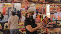 Seorang pelayan menawarkan menu kepada para pengunjung Festival Sandwich Meksiko edisi ke-17 Meksiko di Alcaldia Venustiano Carranza Esplanade.