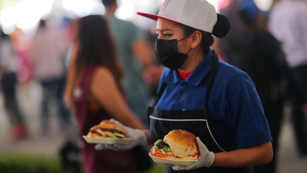 Seorang pelayan membawakan sandwich ke salah satu pengunjung festival tersebut.