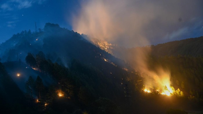 Suasana kebakaran lahan di Bukit Parombahan, Desa Aek Sipitudai, Sianjur Mulamula, Samosir, Sumatera Utara, Minggu (7/8/2022) malam. Kepala Daops Manggala Agni Sumatera Utara (MAS) II Anggiat Sinaga  menyebutkan, kebakaran hutan dan lahan (karhutla) menghanguskan sekitar 49 hektare lahan di empat desa meliputi Sipitu Dai, Janji Martahan, Simulop, dan Sabulan di daerah itu, sementara hingga Senin (8/8) siang petugas masih mengupayakan pemadaman. ANTARA FOTO/Fransisco Carolio/WS/aww.